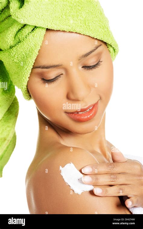 Attractive Woman Rubbing A Body Lotion On Her Arm Side View Wrapped In Towel With Turban