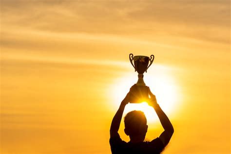 Premium Photo Silhouette Of A Winning Man Holding Golden Champion