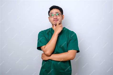 Premium Photo Asian Male Doctor In Scrubs Looking Thinking Searching