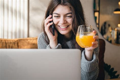 Mulher Jovem E Atraente Falando Ao Telefone E Trabalhando Em Um Laptop