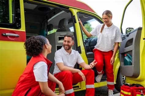 ambulanciers paramédicaux multiethniques debout devant une ambulance médecin d urgence et