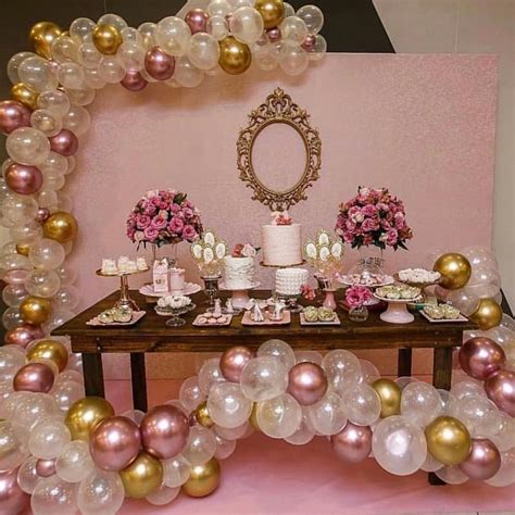 A Table Topped With Lots Of Balloons Next To A Pink And Gold Dessert Set Up