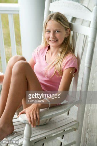 Caucasian Preteen Girl Sitting In Rocking Chair On Porch Smiling High