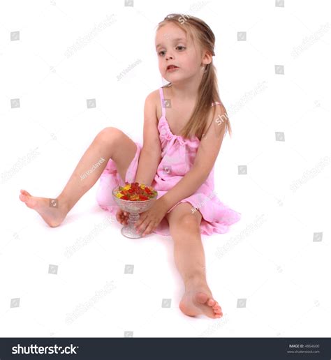 Small Girl In Pink Dress Sitting On The Floor And Eating