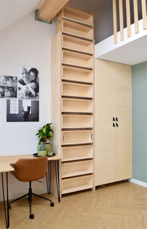 A Room With A Chair Desk And Bookshelf Next To A Stair Case
