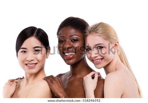 concept of three different ethnicity of women being very close one to each other and looking