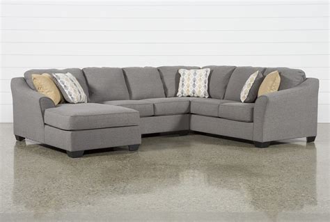 A Gray Sectional Couch With Pillows On The Top And Bottom Corner In