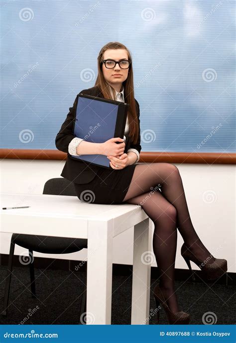 le jeune professeur s assied sur votre bureau dans la classe photo stock image du noir