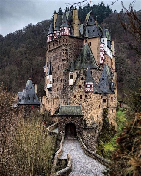 An Old Castle Sitting On Top Of A Hill Next To A Forest Filled With Trees