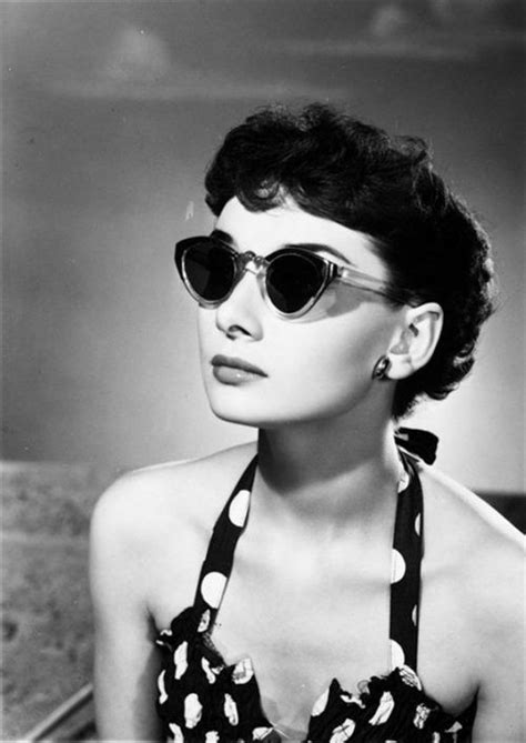 a woman wearing sunglasses and a halter top with polka dots on the neckline