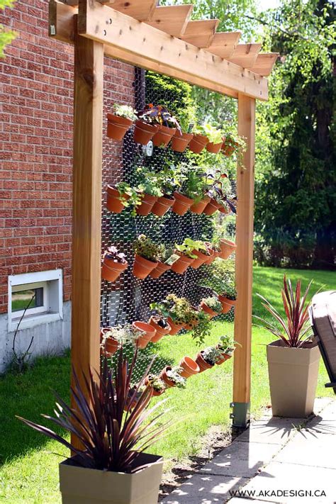 Home made planters from repurposed wood, vertical positioned pallets to make living wall vertical garden divisions. How to Build Your Own DIY Vertical Garden Wall