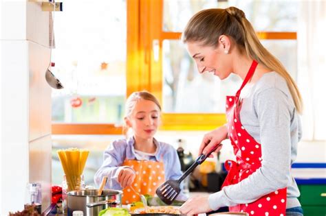 Madre Enseñando A Su Hija Cocinando En Casa Foto Premium