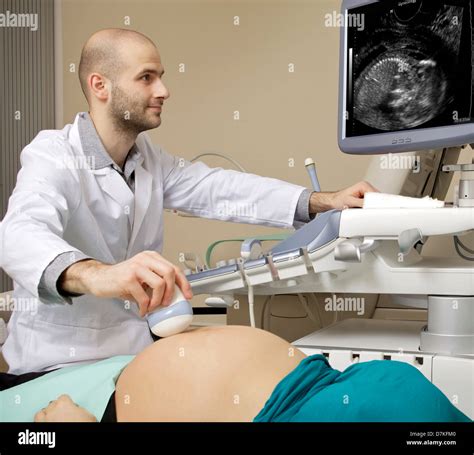Portrait Of Young Male Technician Operating Ultrasound Machine In White