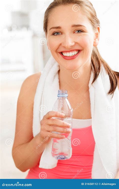 Portrait Of Attractive Young Woman Drinking Water At Gym Stock Photo