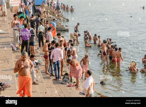 Indian Pilgrims Perform Early Morning Bathing Rituals In The River Ganges In Varanasi Uttar