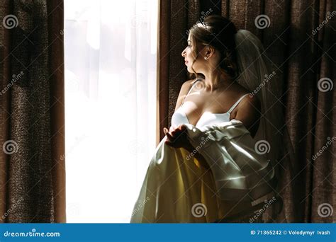 La Giovane Sposa Sta Tenendo Il Suo Vestito Nuziale Fotografia Stock Immagine Di Immaginazione