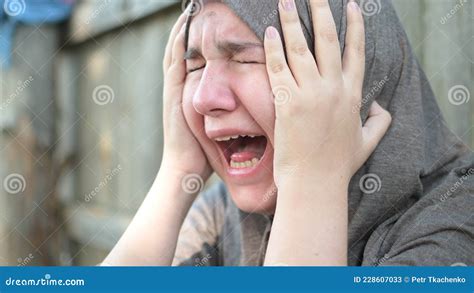 A Teenage Refugee Girl Is Crying And Screaming Holding Her Head In Her