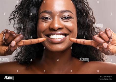 Gerne schwarze Frau an ihrem perfekten weißen Zähne zeigen