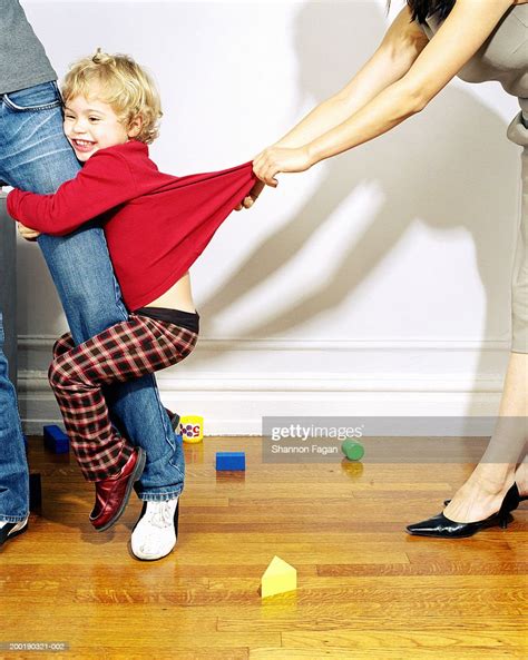 Woman Tugging Girl Clinging To Mothers Leg Low Section Photo Getty Images