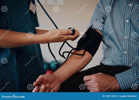 Closeup Of Young Nurse Hands Measuring Patient Blood Pressure Stock