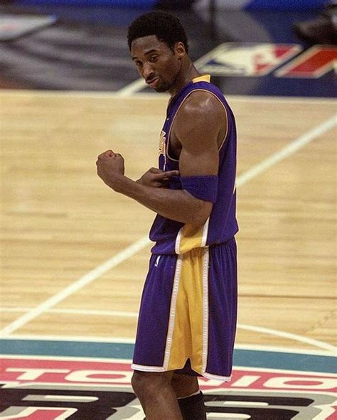 A Man Standing On Top Of A Basketball Court Wearing A Purple And Yellow