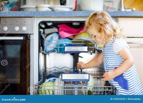 Little Adorable Cute Toddler Girl Helping To Unload Dishwasher Funny