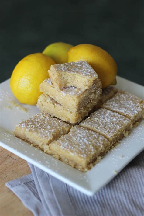 2 lemon squares stacked on plate with lemon slices. Low Carb Lemon Bars | Keto Lemon Bars