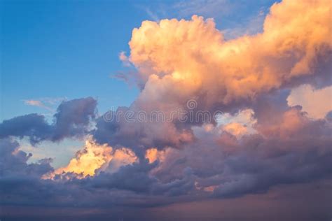 Big Fluffy Yellow And Blue Clouds In Bright Blue Sky Stock Image