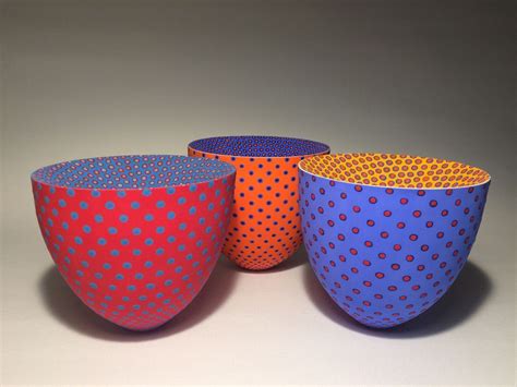 Three Colorful Bowls Sitting Next To Each Other On A Table