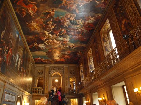 Several People Are Standing In A Large Room With Paintings On The Ceiling