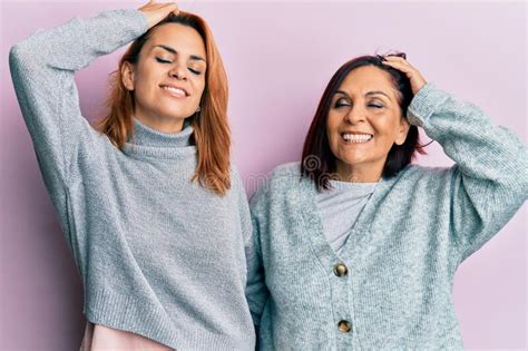 Latin Mother And Daughter Wearing Casual Clothes Smiling Confident Touching Hair With Hand Up