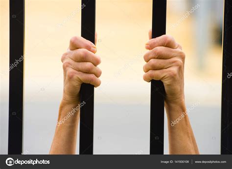 Female Hands Behind Bars In Prison — Stock Photo © Roboriginal 141930108
