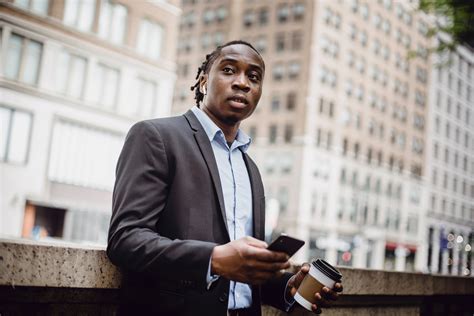 Confident Black Manager Using Smartphone During Coffee Break On Terrace