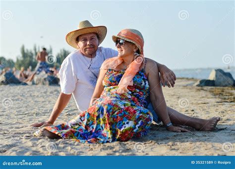 mature couple sitting at seashore on summer sandy beach outdoors background stock image image