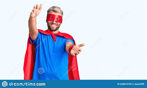 Young Blond Man Wearing Super Hero Custome Looking At The Camera