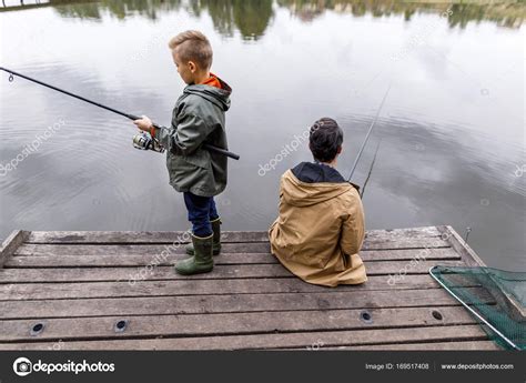 Padre E Hijo Pescando Con Cañas Fotografía De Stock © Sashakhalabuzar