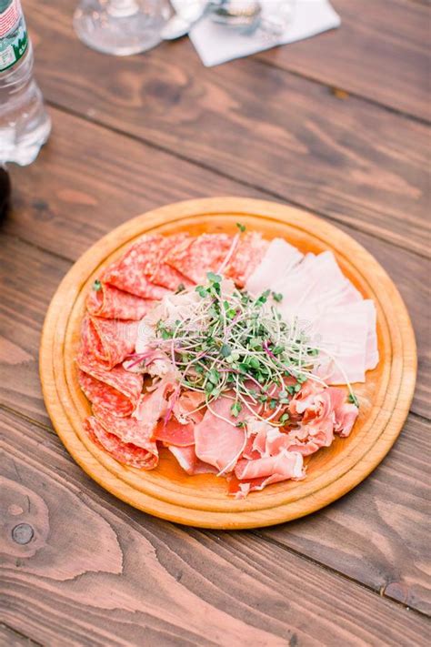 Food Wooden Plate With Delicious Salami Pieces Of Sliced Ham Sausage