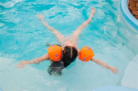 Little Girls Is Swimming In The Pool By A Summer Day Stock Photo