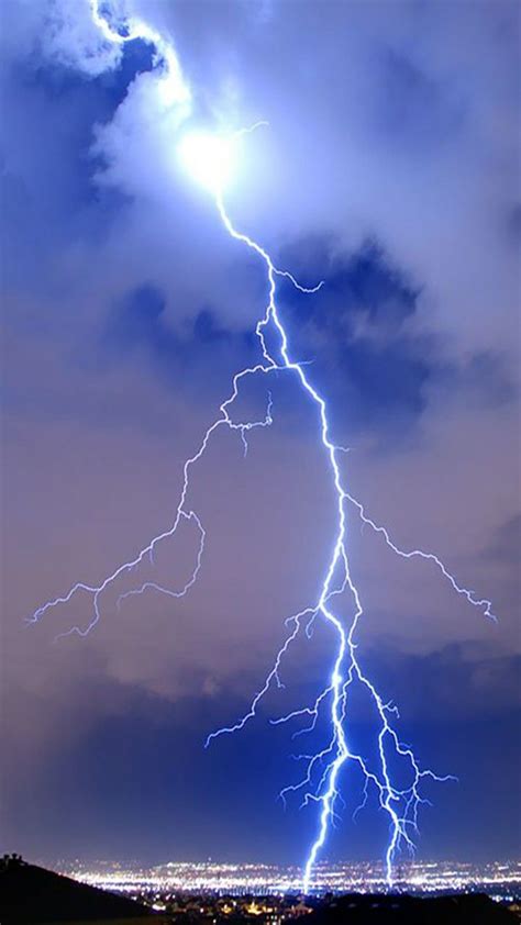 A Lightning Bolt Is Seen In The Sky Over A City