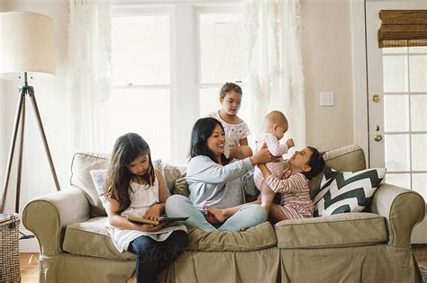 Mom And Four Daughters On Couch Reading For Homeschool By Stocksy Contributor Kristin Rogers