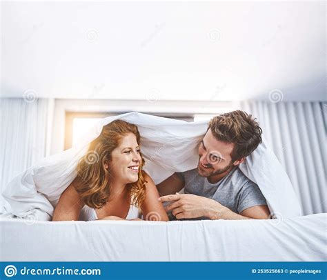 Love Is A Tender Sweet Feeling A Couple Relaxing Together Underneath A Blanket At Home Stock