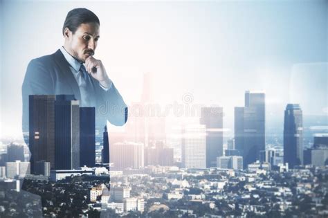 Handsome Businessman Standing On Abstract City Background Stock Photo