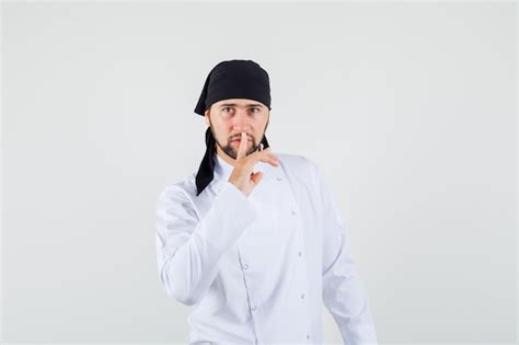 Free Photo Male Chef Showing Silence Gesture In White Uniform And Looking Careful Front View