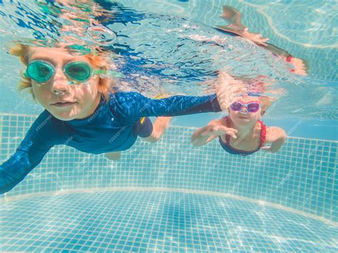 Premium Photo Kids Having Fun Playing Underwater In Swimming Pool On