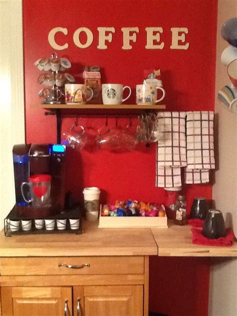 The Coffee Bar Has Many Cups On It And There Is A Red Wall In The