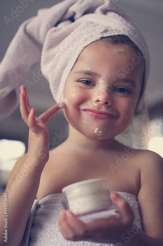 Little Girl Putting Cream On Her Face Stockfotos Und Lizenzfreie
