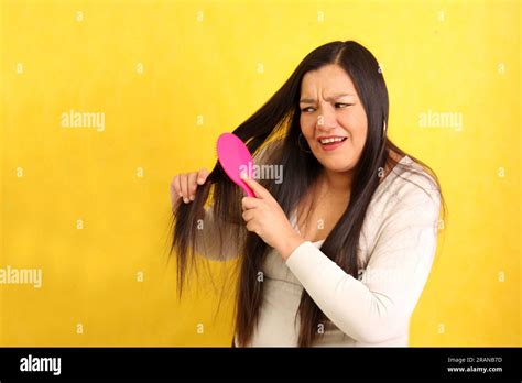 Adult 40 Year Old Latina Woman Brushes Her Hair With Difficulty Because