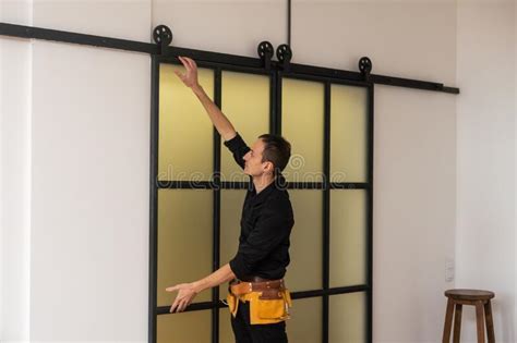 Male Workers Carpenters Installing Interior Glass Door With A Wooden