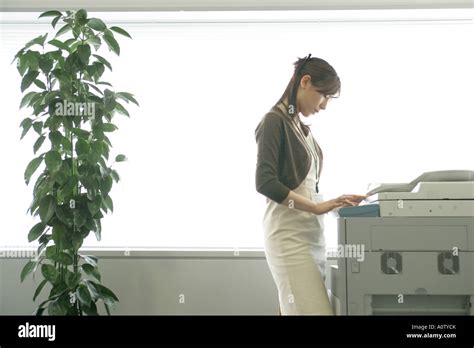 Side Profile Of A Businesswoman Using A Photocopier Stock Photo Alamy