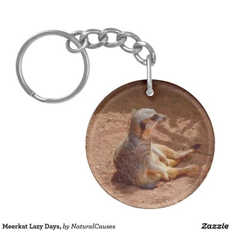 A Keychain With A Picture Of A Meerkat Laying On The Ground